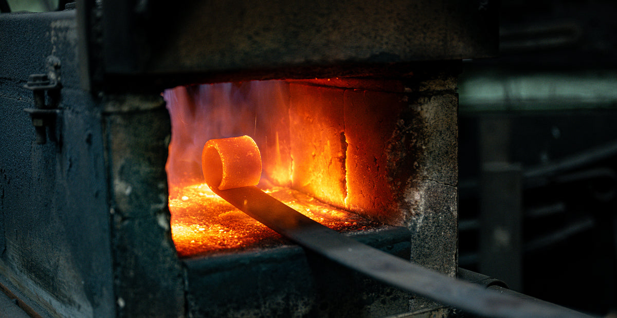 Fabrication sur mesure d'une lame de ressort en acier chauffée à blanc dans une forge industrielle chez Edgar Blondeau, expert en véhicules lourds.